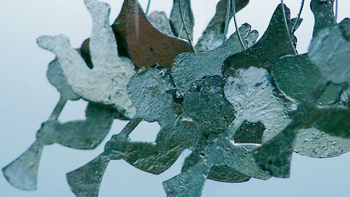 Gläserne Vögel hängen an rotem Draht