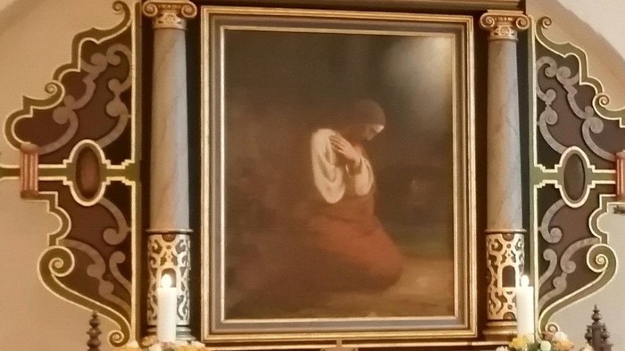 Kirkealter med religiøst maleri og tekst på dansk.