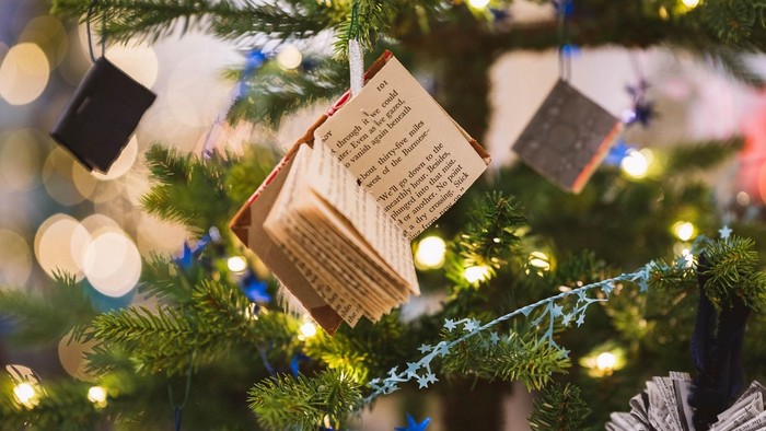 Ein Weihnachtsbaum mit selbstgebastelten Schmuckstücken aus Papier und blauen Sternen.