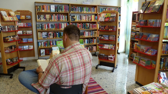 Mann liest in gemütlicher Buchhandlung
