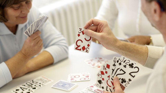 Drei Personen spielen Karten