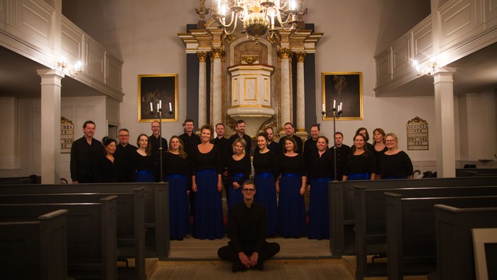 En kor poserer i en kirke foran alteret