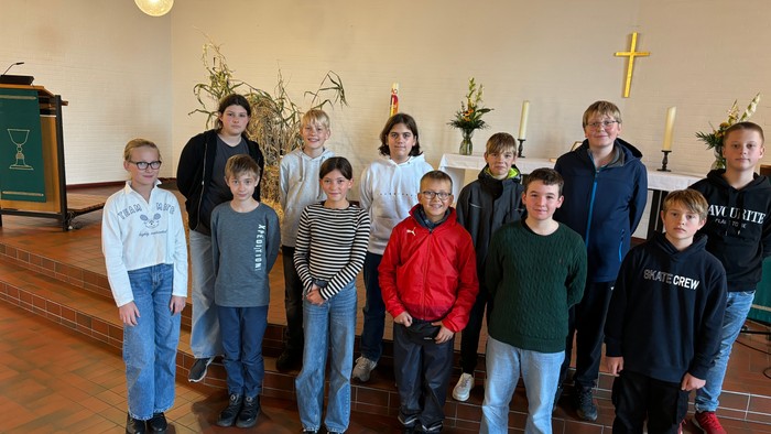 Eine Gruppe von Kindern und Jugendlichen posiert in einer Kirche vor einem Altar