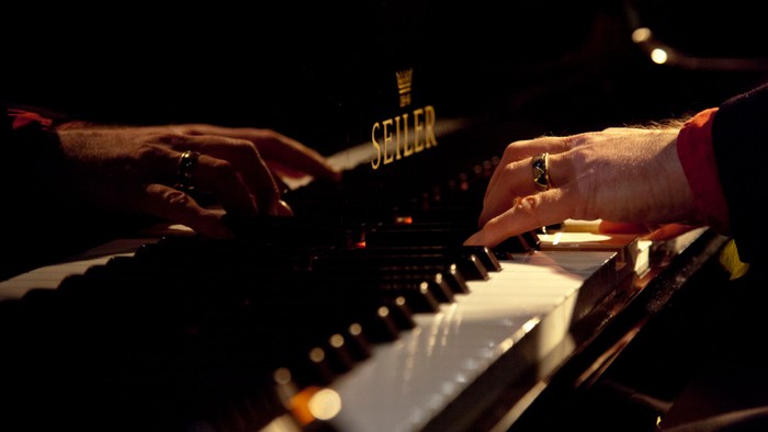Hände, die Klavier spielen, mit sichtbarem Seiler-Logo.