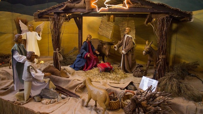 Eine Krippe mit Figuren und Stroh, unter einem Sternenhimmel