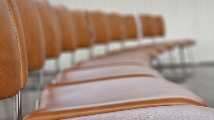 En rekke orangefarvede læderstole.