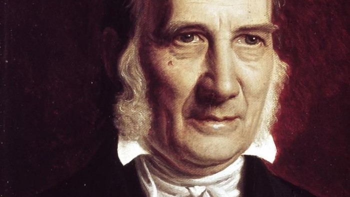 Portræt af en ældre mand i formelt tøj med et alvorligt udtryk og hvidt skæg.