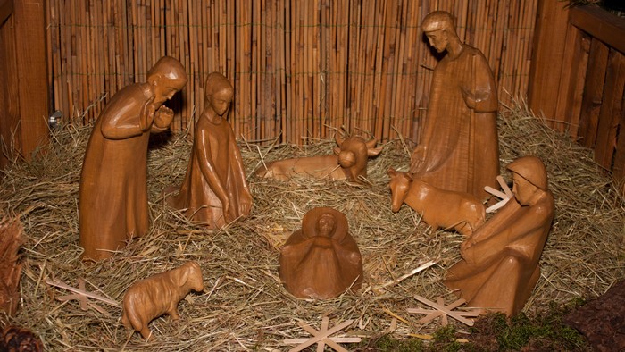 Die Krippe zeigt Holzfiguren von Maria, Josef und dem Jesuskind.