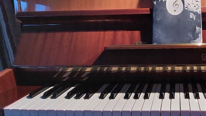 Ein Piano mit Notenbüchern und einem Notizbuch darauf