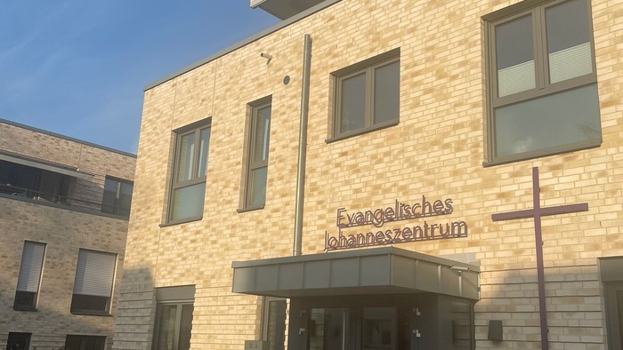 Neues Gebäude mit Kreuz und Schilder "Evangelisches Krankenhaus"