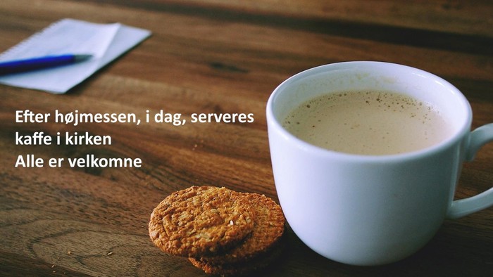 Et cup med kaffe og en kage på bordet