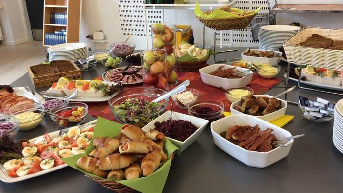 Bord med mange retter og madretter, inklusiv salater, kager og drikkevarer