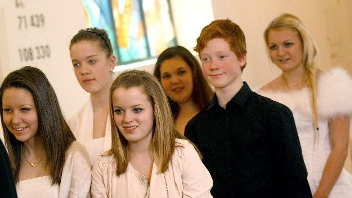 En gruppe unge står sammen og smiler til kameraet