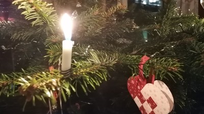 En juletree med lysende lys, pynt med hjerter og stjerner