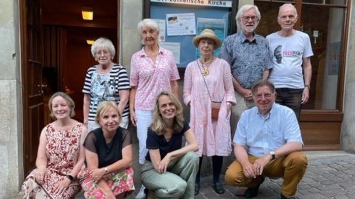 Eine Gruppe von Menschen posiert vor einem Gebäude