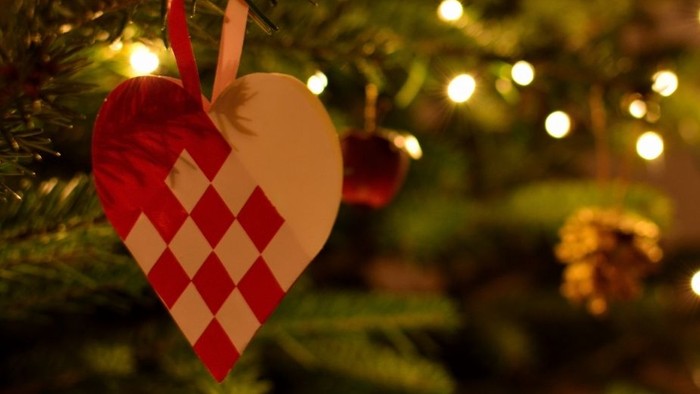 En juledekorationshjerte hænger på en juletree