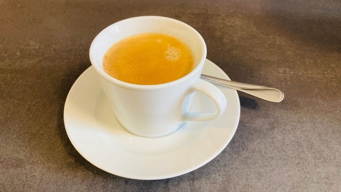 Eine Tasse Tee auf einem Unterteller mit Löffel