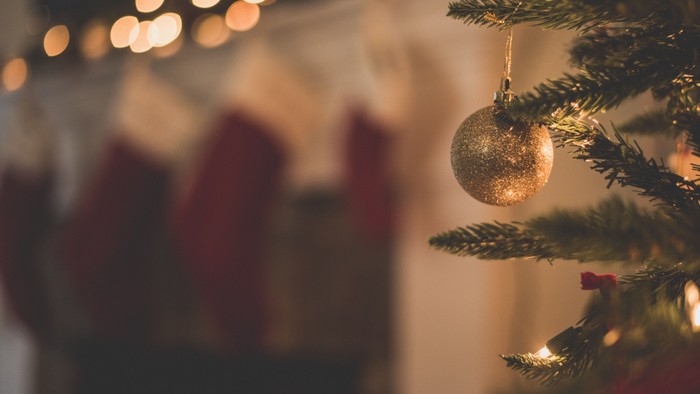 Ein Weihnachtsbaum mit goldenen Kugeln und Lichtern im Hintergrund