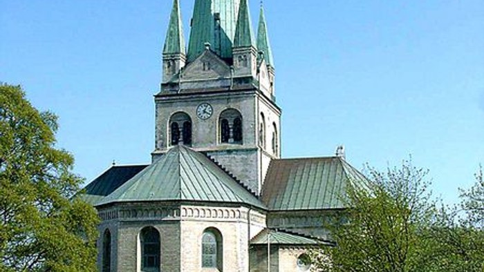 Gammel kirke med spire og træer.