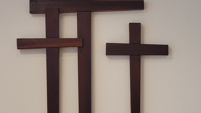 Drei hölzerne Kreuze hängen an der Wand