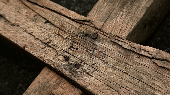 Holzstücke mit Nägeln auf schwarzem Hintergrund