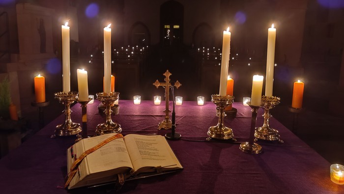 Kirchenaltar mit brennenden Kerzen und aufgeschlagenem Buch