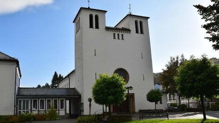Weiße Kirche mit zwei Türmen und grünem Rasen davor