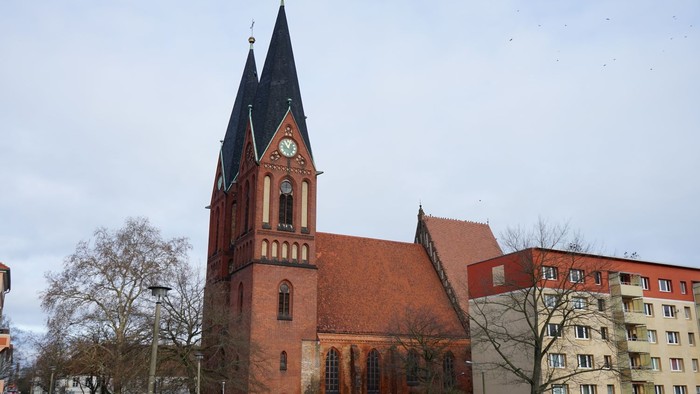 Friedenskirche. Klassischer Backsteinbau mit Satteldach und zwei spitz zulaufenden Türmen.