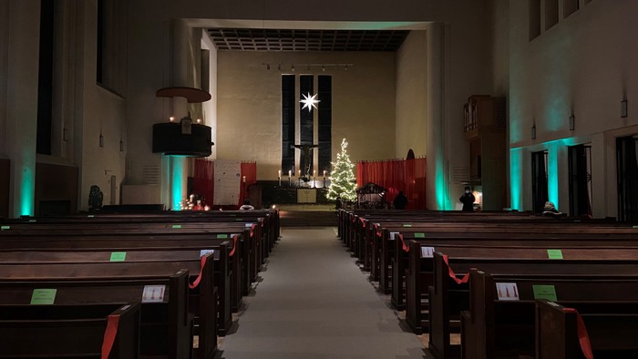 Weiter Blick in die weihnachtlich beleuchtete Kirche mit Weihnachtsbaum