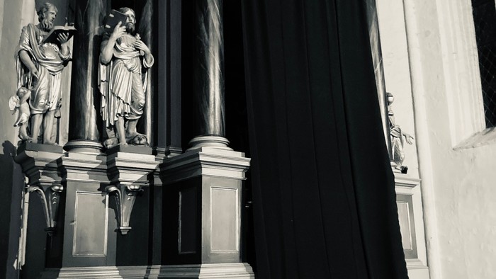 Dunkler Vorhang vor Säulen und Statuen
