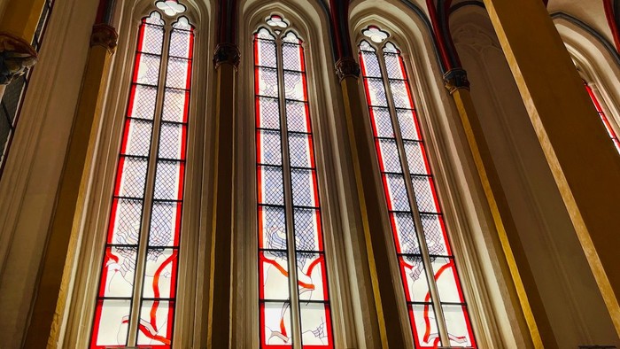 Drei bunte Kirchenfenster mit Kreuzsymbolen