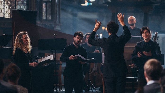 Ein Live-Musikkonzert mit Dirigenten und Musikern, die das Publikum begeistert in einem Konzertsaal einbeziehen.
