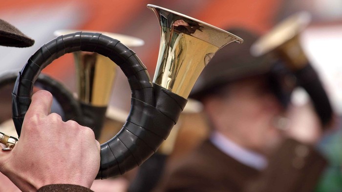 Eine Person spielt eine schwarze und goldene Horn.
