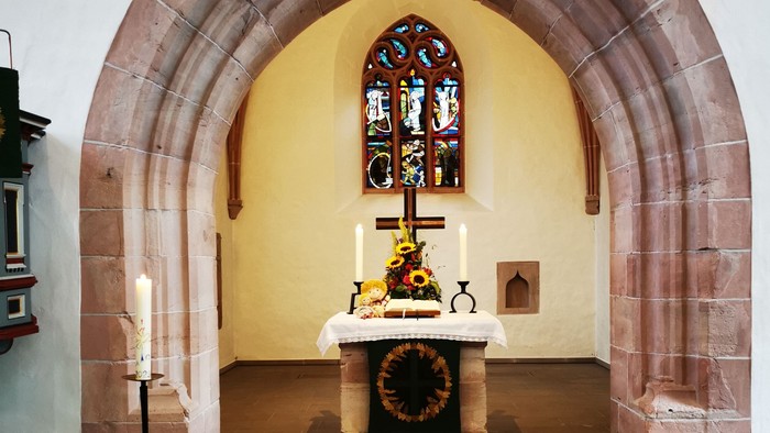 Gotteshaus mit Altar und Buntglasfenster