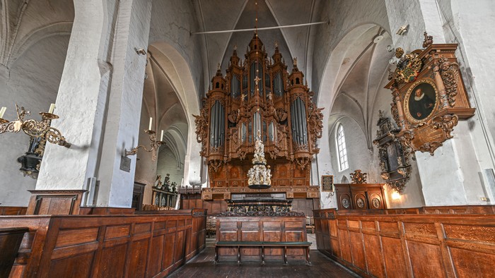 Innenraum einer Kirche mit Holzvertäfelung und großem Orgelpfeifenwerk