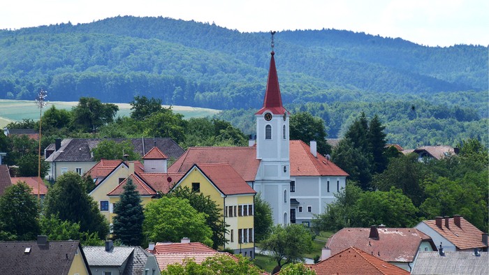 Ein Dorf mit Kirche und umgebenden Hügeln