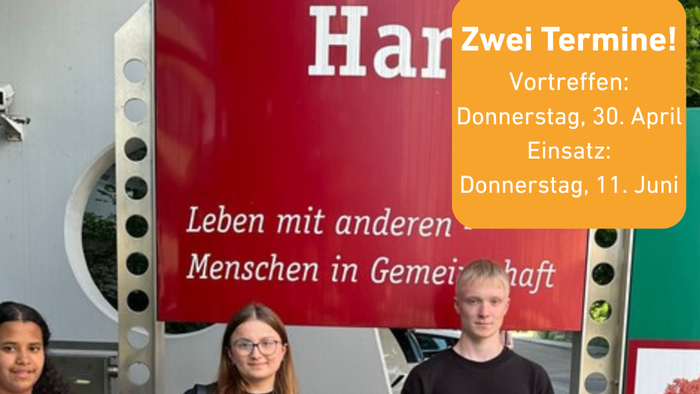 Drei Personen posieren vor einem Schild, das zwei Termine für Gemeinschaftsveranstaltungen des „Wohnstifts Hartmann“ bewirbt.