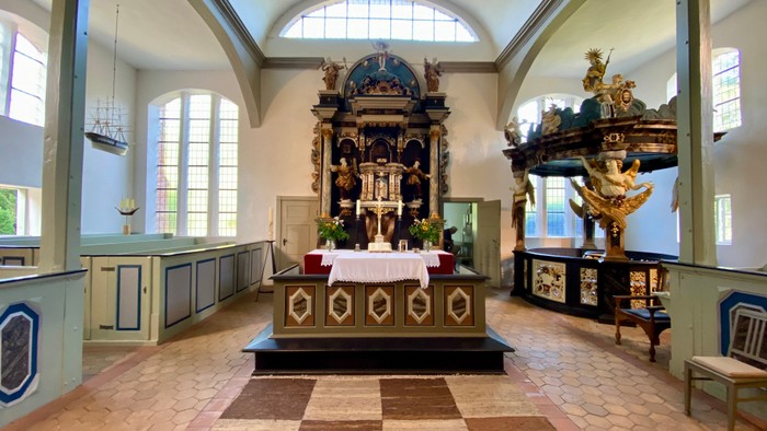 Innenraum einer Kirche mit Altar und hohen Fenstern