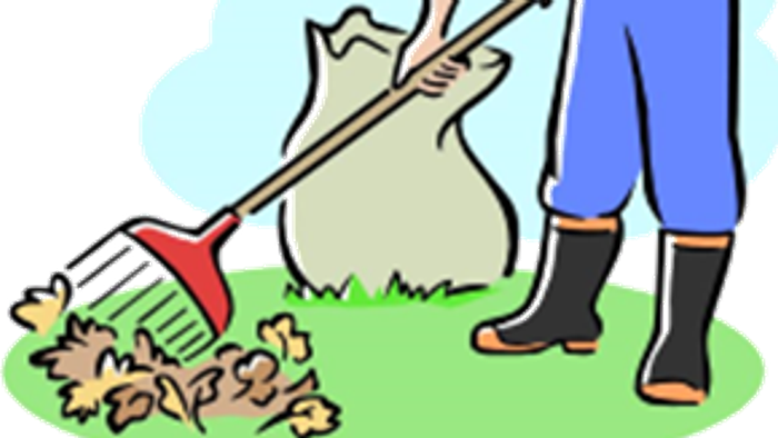 Ein Mann kehrt Blätter in den Garten.