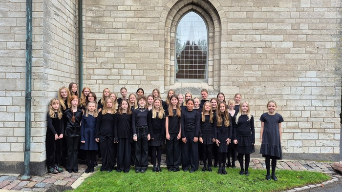 Piger i sorte kjoler foran kirke