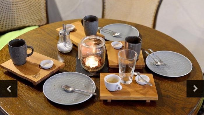 Ein Holztisch mit verschiedenen Geschirrstücken und einer Kerze