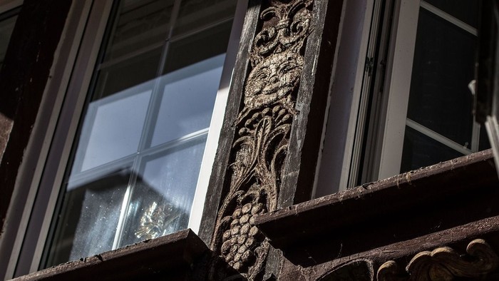 Das Bild zeigt ein verziertes Fenster mit aufwendigen Schnitzereien.