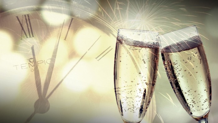 To glas med mousserende vin og ur i baggrunden 