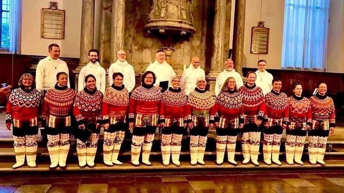 En gruppe i traditionelle klæder poser i en kirke.