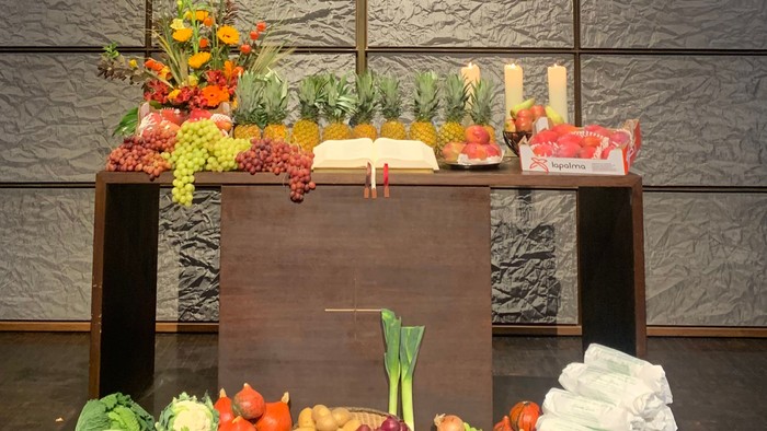 Bunte Auswahl an frischem Obst, Gemüse und Backwaren, arrangiert auf einem Holztisch.