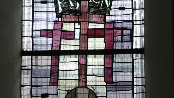Buntglasfenster mit der Darstellung der „Passion“ mit einem Kreuz und religiösen Motiven.