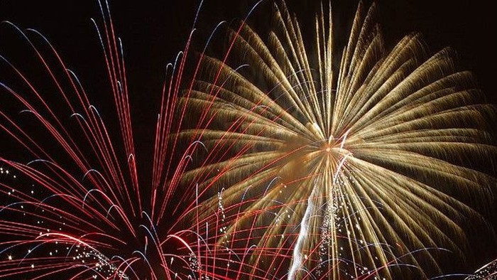 Billede af fyrværkeri i mørke himmel.