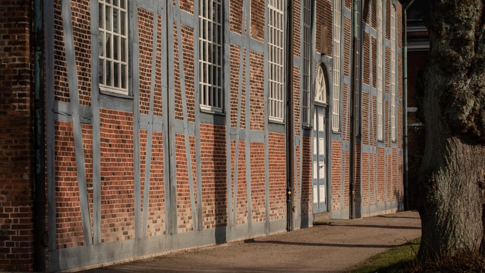 Alte Backsteingebäude mit hohen Fenstern und Metallgittern