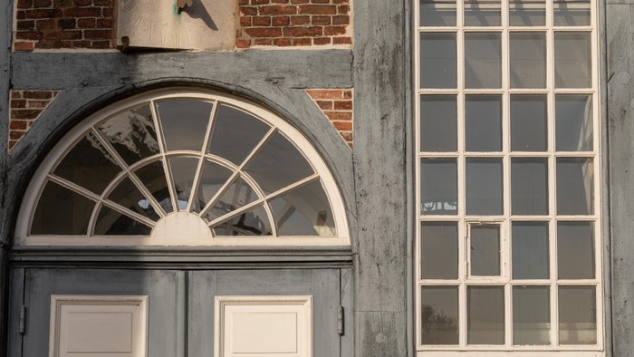 Historisches Backsteingebäude mit Bogenfenster und angrenzendem rechteckigem Industrie-Stil-Fenster.