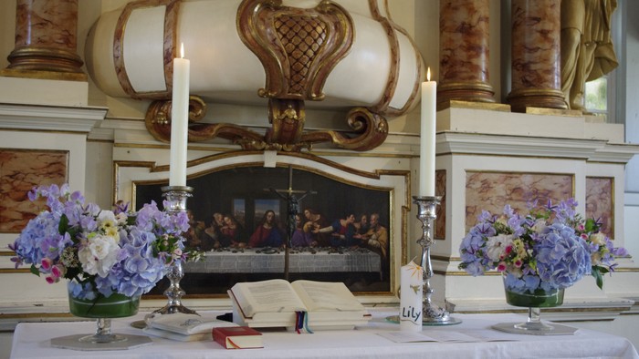 Elegante Tischdekoration mit Blumen und Kerzen in historischem Raum